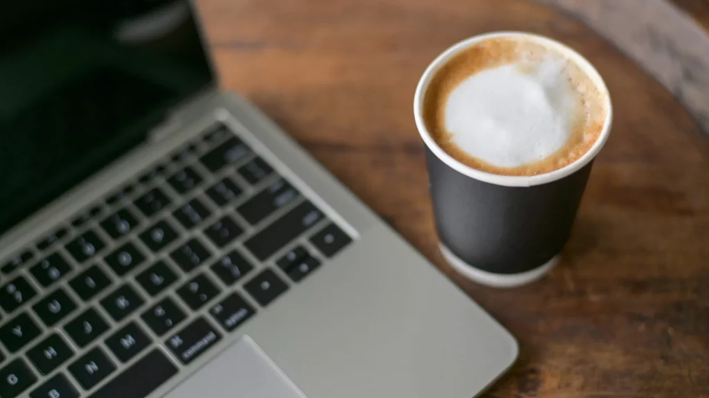 Laptop mit Kaffee zum Thema WordPress Wartung Kosten und Website-Betreuung