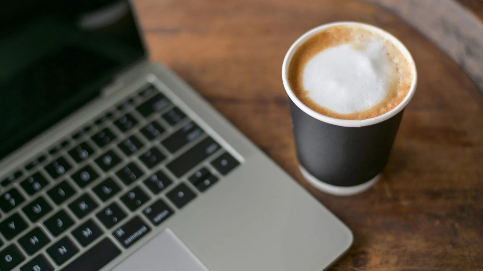 Laptop mit Kaffee zum Thema WordPress Wartung Kosten und Website-Betreuung